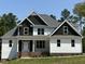 Two-story home with white and dark gray siding, brick accents, and large windows at 190 Whistlers Cv, Louisburg, NC 27549