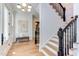 Light-filled entryway with hardwood floors, staircase and artwork at 1817 N Lakeshore Dr, Chapel Hill, NC 27514
