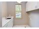 Laundry room with white cabinets, quartz countertops and window at 1817 N Lakeshore Dr, Chapel Hill, NC 27514