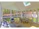 Bright screened porch features a seating area and dining set with wooded views at 1817 N Lakeshore Dr, Chapel Hill, NC 27514