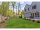 Farmhouse-style home with expansive backyard and patio area, surrounded by trees at 1817 N Lakeshore Dr, Chapel Hill, NC 27514