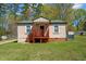 One-story home with green roof, wooden deck, and lawn at 221 Stroud St, Sanford, NC 27330