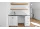 Modern wet bar with white cabinets, dark countertop, and open shelving at 52 Barn Owl Ln, Pittsboro, NC 27312