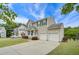 Two-story house with a beige exterior, green shutters, and a two-car garage at 100 Plumbago Pl, Holly Springs, NC 27540