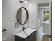 Stylish bathroom with a round mirror and modern vanity at 825 Chalmers St, Durham, NC 27707