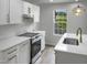 Modern kitchen with white cabinets, gold hardware, and quartz countertops at 825 Chalmers St, Durham, NC 27707