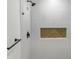 Clean shower with white tiles and a wood accent at 825 Chalmers St, Durham, NC 27707