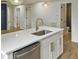 Kitchen island with white cabinets, quartz countertop, and gold faucet at 825 Chalmers St, Durham, NC 27707