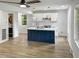 Modern kitchen with white cabinets, a blue island, and new appliances at 825 Chalmers St, Durham, NC 27707