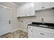 Laundry room with white cabinets, dark countertop, and tile floor at 112 Lambert Ln, Fuquay Varina, NC 27526