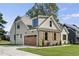 Two-story craftsman home with stone accents and a large wooden garage door at 112 Lambert Ln, Fuquay Varina, NC 27526
