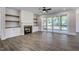 Open living room with hardwood floors, fireplace, and sliding glass doors to deck at 112 Lambert Ln, Fuquay Varina, NC 27526