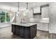 Modern kitchen with a large island, white cabinets, and hardwood floors at 112 Lambert Ln, Fuquay Varina, NC 27526
