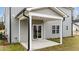 Covered back patio with sliding glass door and green lawn at 535 Husketh Rd, Youngsville, NC 27596