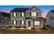 Two-story home with gray siding, stone accents, and a covered front porch at twilight at 535 Husketh Rd, Youngsville, NC 27596