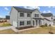 View of a two-story gray home with black shutters and a stone and columned front porch at 535 Husketh Rd, Youngsville, NC 27596