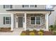Covered front entry with stone accents, gray door, sidelights, and white columns at 535 Husketh Rd, Youngsville, NC 27596
