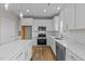 Spacious white kitchen with stainless steel appliances, a kitchen island and wood-look floors at 535 Husketh Rd, Youngsville, NC 27596