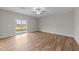 Living room with wood-look floors, sliding glass door, and neutral paint at 535 Husketh Rd, Youngsville, NC 27596