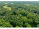An aerial view showcasing a vast expanse of lush forest and a glimpse of residential areas at 3721 Brightwood Ln, Durham, NC 27703