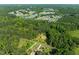 Aerial view of a house nestled in a wooded area near a residential neighborhood and a lake at 3721 Brightwood Ln, Durham, NC 27703
