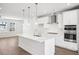 Modern kitchen with island, stainless steel appliances, and white cabinets at 4711 Cypress Tree Ln, Raleigh, NC 27612