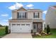 Two-story house with a white garage door and stone accents at 600 Rhino Bnd, Oxford, NC 27565