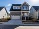 Inviting two-story home with gray exterior, white garage door, and brick stairs at 1713 Grassy Falls Ln, Wendell, NC 27591