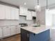 Modern kitchen with white cabinets, dark blue island, and speckled countertops at 1713 Grassy Falls Ln, Wendell, NC 27591