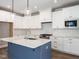 Bright, open kitchen featuring white shaker cabinets, quartz countertops, and stainless steel appliances at 1713 Grassy Falls Ln, Wendell, NC 27591