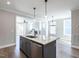 Kitchen island with quartz countertop, farmhouse sink, and view to the dining and living area at 1713 Grassy Falls Ln, Wendell, NC 27591