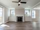 Living room with a modern fireplace, built-in cabinets, large windows, and a ceiling fan at 1713 Grassy Falls Ln, Wendell, NC 27591