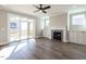 Living room with fireplace, ceiling fan, and sliding glass doors leading to a porch at 1713 Grassy Falls Ln, Wendell, NC 27591