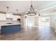 Open concept kitchen and living area with dining space, wood flooring, and modern light fixtures at 1713 Grassy Falls Ln, Wendell, NC 27591