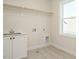 Bright laundry room with a sink and overhead shelving at 1719 Grassy Falls Ln, Wendell, NC 27591
