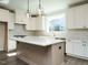 Modern kitchen with white cabinets, quartz countertops, and an island at 1719 Grassy Falls Ln, Wendell, NC 27591
