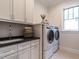 Laundry room features a sink, washer, dryer, and ample cabinetry at 1113 Destination Dr, Apex, NC 27523