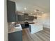 Modern kitchen with gray cabinets, island, and stainless steel appliances at 260 Chestnut Oak Ln, Lillington, NC 27546
