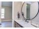 Bathroom boasts a round mirror and modern vanity with quartz countertop at 40 Harvest View Way, Franklinton, NC 27525