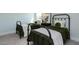 Cozy bedroom with two twin beds, green bedding, and a zebra print art piece at 213 Beacon Dr, Pittsboro, NC 27312