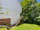 Home's exterior showcases wooden stairs leading to a deck and a grassy backyard at 4425 Woodlawn Dr, Raleigh, NC 27616