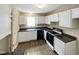 Efficient kitchen featuring white cabinets, dark countertops, and vinyl flooring at 4425 Woodlawn Dr, Raleigh, NC 27616