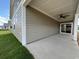 Covered patio with ceiling fan, adjacent to grassy yard at 231 Village Walk Dr, Clayton, NC 27527
