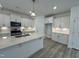 Open kitchen with island, white cabinets, and stainless steel appliances at 231 Village Walk Dr, Clayton, NC 27527