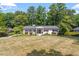 House with large backyard, circular driveway, and lush green trees at 4937 Carteret Dr, Raleigh, NC 27612