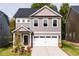 Two-story home with gray siding, white garage door and landscaping at 81 Hank Way, Angier, NC 27501