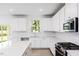 Modern kitchen with white cabinets, quartz island and stainless steel appliances at 81 Hank Way, Angier, NC 27501