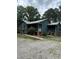 Green house with a gravel driveway and mature trees at 7253 Hunt Valley Trl, Wendell, NC 27591