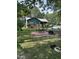 Green house with patio furniture and a fire pit in the yard at 7253 Hunt Valley Trl, Wendell, NC 27591
