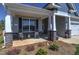 Inviting front porch features rocking chairs, stone pillars, and lush landscaping at 3102 Castlerock Dr # 2, Burlington, NC 27215